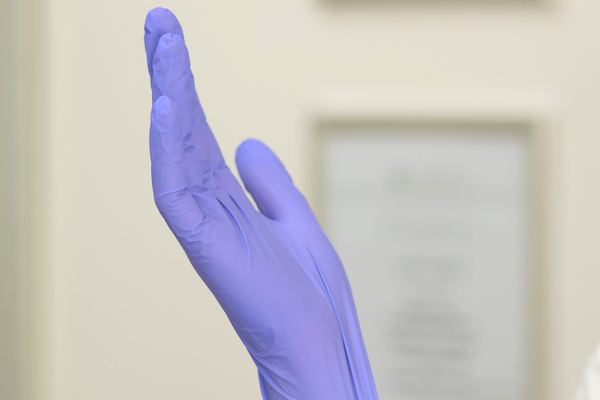 Hands putting on medical gloves