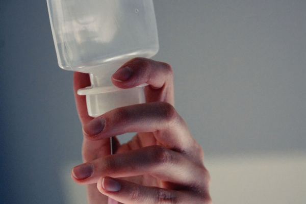 Hand holding an intravenous fluid bag